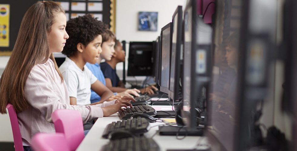 Line Of High School Students Working at Screens In Computer Class
