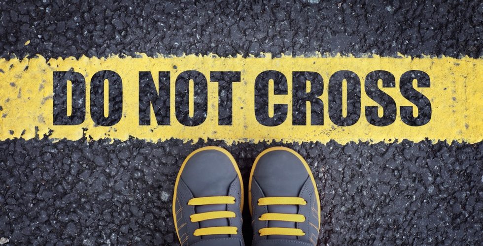 Do not cross line child in sneakers standing next to a yellow line with restriction or safety warning